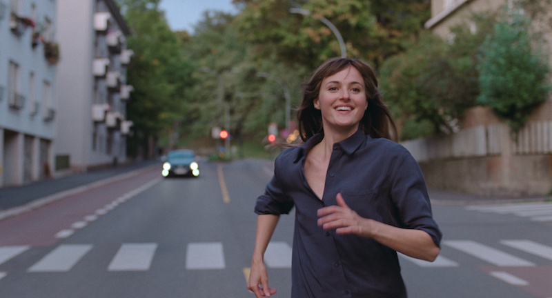renate reinsve running on a street in a scene from the film The Worst Person in The World
